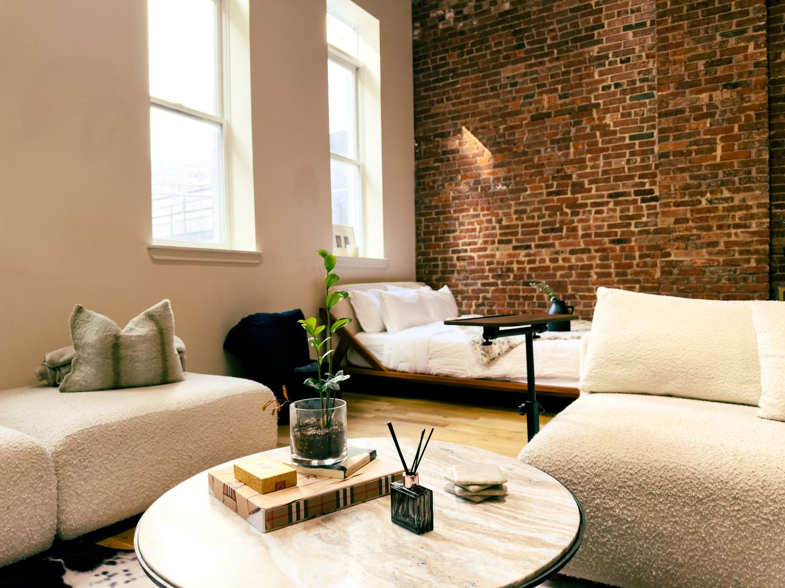 Boucle lounge and bedroom against original brick